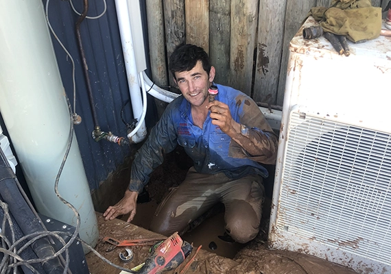 Mark Ryan, covered in mud and finding a blockage
